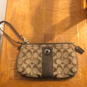 Coach Wristlet 9/1/2 inches wide, 6 inches long. The color beige and brown.
